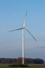 Huge wind turbine standing in the middle of a field in the Polish countryside