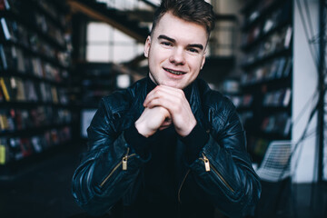 Happy young guy resting in modern library