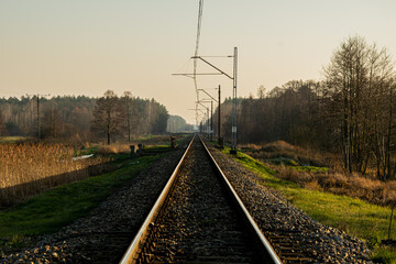 Fototapeta na wymiar An railway track with a single track leading through meadows and forests