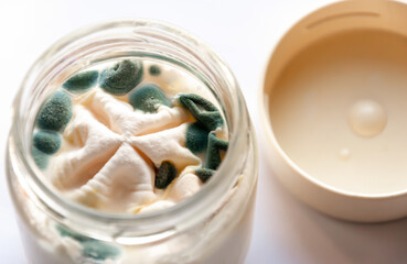 Yogurt with mold in a glass jar.Spoiled food.