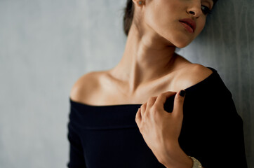 Fototapeta na wymiar elegant brunette in evening dress leaning against the wall indoors