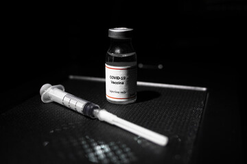 covid 19 corona virus cure treatment vaccine with syringe black background