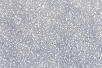 Snow, the texture of the surface of white snow with large crystals, illuminated by the oblique rays of the winter sun, background.