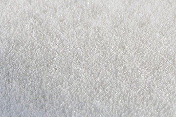 Snow, the texture of the surface of white snow with large crystals, illuminated by the oblique rays of the winter sun, background.