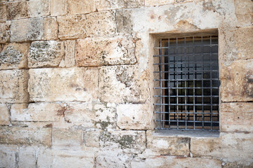 Fototapeta na wymiar Lattice on the window of a fortress from the era of the Roman Empire