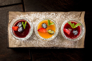 assorted panna cotta with jam decorated with fruit