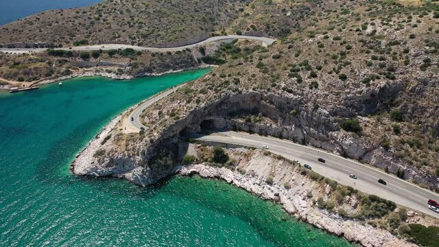 Aerial drone video of Tunnel in Athens riviera seaside road known as hole of Karamanlis or "Tripa of Karamanlis", Attica, Greece