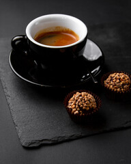 cup of coffee with candy, truffle on black background