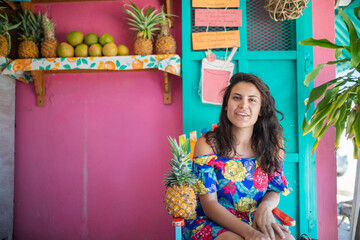 Beautiful woman sitting on a colorful chair in a juice store