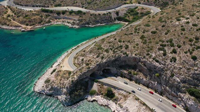 Aerial drone video of Tunnel in Athens riviera seaside road known as hole of Karamanlis or "Tripa of Karamanlis", Attica, Greece