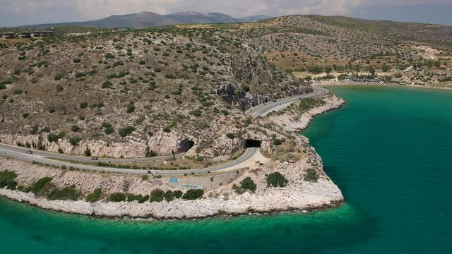 Aerial drone video of Tunnel in Athens riviera seaside road known as hole of Karamanlis or "Tripa of Karamanlis", Attica, Greece