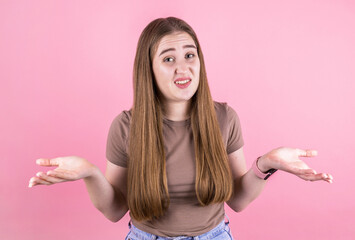 Portrait of ute lovely woman showing I don't know gesture isolated over pink background