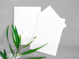White paper mock-ups with leaves isolated on gray background, Blank portrait paper A4. brochure newspaper magazine, can use poster banners products business texture for your.