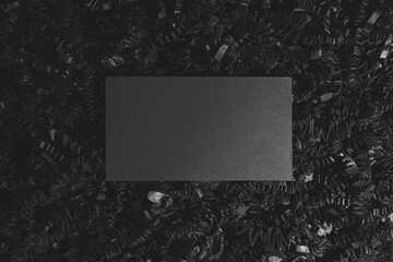 Business concept. Black business card templates with copy space placed on shredder black curly carton paper strips background