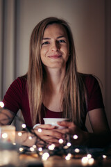 beautiful smile of a young blonde woman of European ethnicity at her morning breakfast. A woman in a red T-shirt is drinking hot tea right now, and she gave the most beautiful smile