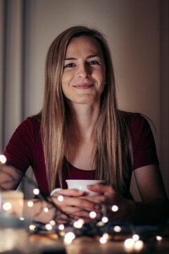 Beautiful Smile Of A Young Blonde Woman Of European Ethnicity At Her Morning Breakfast. A Woman In A Red T-shirt Is Drinking Hot Tea Right Now, And She Gave The Most Beautiful Smile