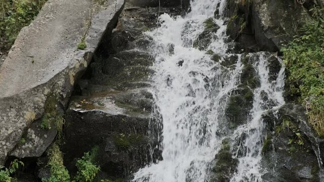 water flows over gray stones, close-up. mini waterfall in the carpathians, daytime