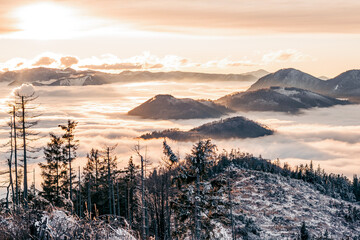 Winter inversion clouds in the mounains at sunset time. Seasonal natural scene with fog, Orava...