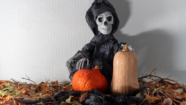 
Death, holding a pumpkin and a butternut, autumn, halloween