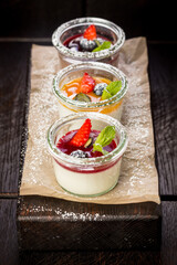 assorted panna cotta with jam decorated with fruit
