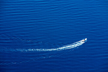 Obraz premium White yacht floating above a coral reef in beautiful bay. Aerial view
