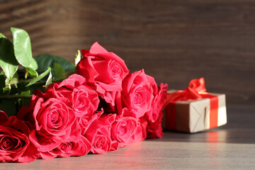Bouquet of red  roses and present boxes on a dark background