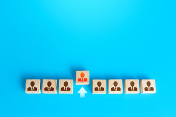 An employee figurine comes out of a row of colleagues. Promotion at work, appointment to the role of team leader. Dismissal of an employee. Take the first step, be different. Initiative and aspiration