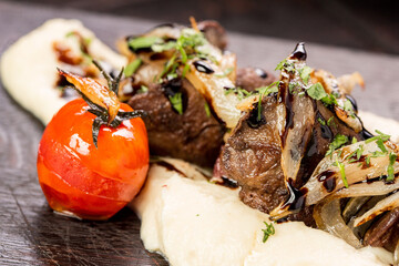Stewed beef cheeks with mashed potatoes on a wooden board