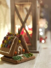 Lebkuchenhaus auf Kaminsims in weihnachtlicher Dekoration 