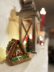 Lebkuchenhaus auf Kaminsims in weihnachtlicher Deko 