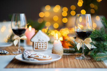 festive Christmas mood with a glass of wine and a burning candle on the kitchen dinner table