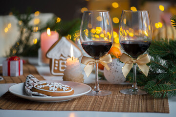festive Christmas mood withtwo glasses of wine and a burning candle on the kitchen dinner table