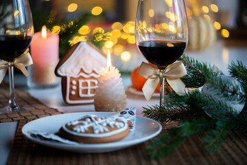 festive Christmas mood with a glass of wine and a burning candle on the kitchen dinner table