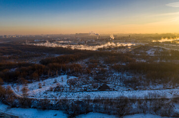 panoramic view of the park in the city on the river bank with old buildings at sunrise in winter filmed from a drone