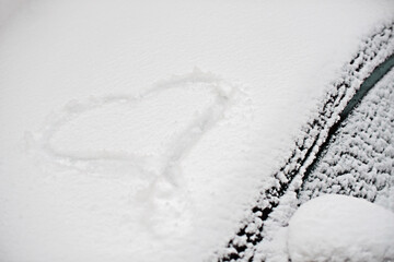 Fototapeta premium snowy heart on the windshield of a car, winter photo