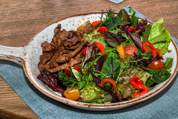 Roast beef slices with vegetables on a white dish