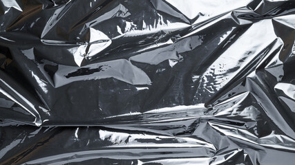 Smooth texture. Black shiny film bag pattern. Wrap transparent dark cellophane background. Real texture of polyethylene foil.