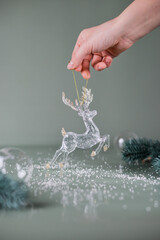 hand holding a glass christmas decoration deer