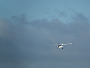Fototapeta na wymiar light aircraft heading off towards a blue cloudy sky
