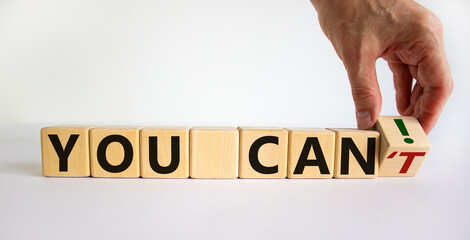 You can symbol. Hand turns a cube and changes the words 'you can't' to 'you can'. Beautiful white background. Concept of business vision and determination. Copy space.