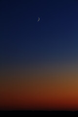 Bright moon in the evening sky after sunset.