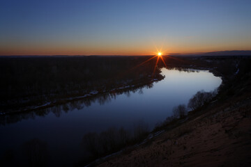 Sunset over the river. Bright clear sky.
