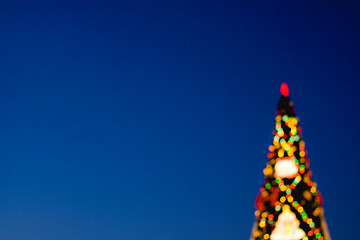 Christmas tree in blurred focus. Bokeh balls of different colors.