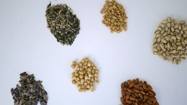 Groups of nuts and seeds on a white table