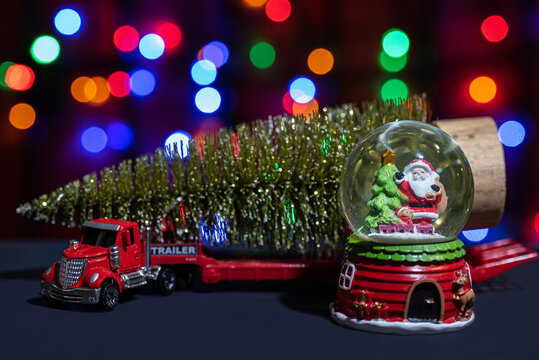 Red toy car with a Christmas tree on a trailer and a snow globe with Santa Claus inside.