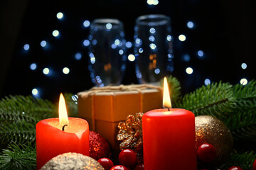 Lighted red candles surrounded by holiday decorations.