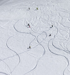 Snowboarders and skiers descend on snowy off-piste slope
