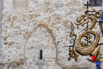 Golden dragon in front of Clock Tower of Sighisoara medieval citadel, Transylvania, Romania