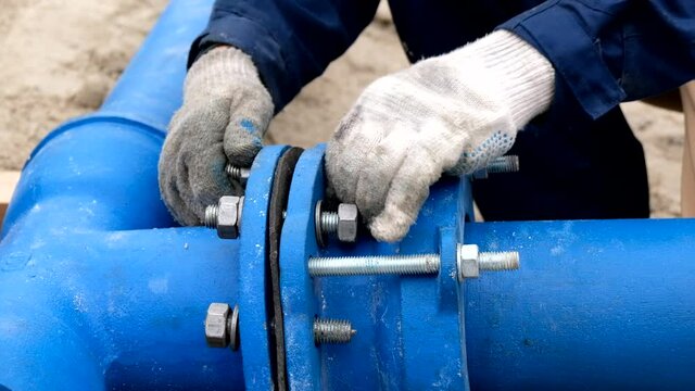Workers installing water supply pipeline system, close up