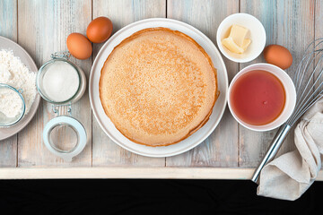 Fried pancakes and ingredients on a light background. Top view, with space to copy. Concept of cooking, Maslenitsa.
